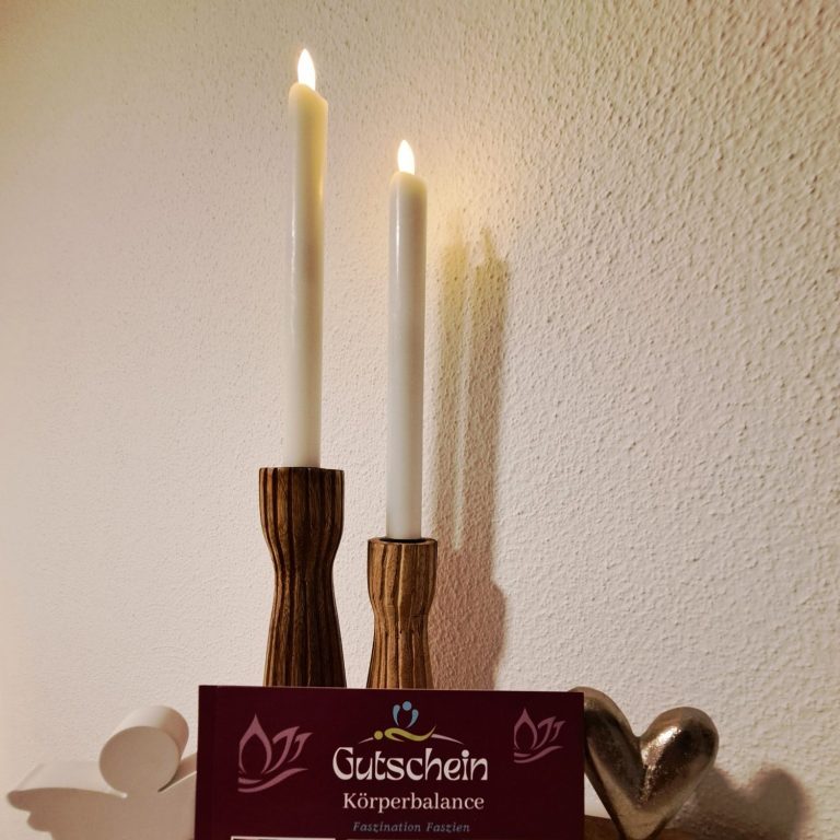 Kerzenlicht und Geschenkgutschein für Faszienbehandlungen – Wohlfühlatmosphäre in der Praxis in Bekond.